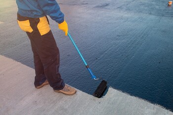 Roofer applying roof coating in Youngtown, AZ